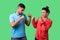 Come on let`s fight! Portrait of lovely couple in casual wear standing together. isolated on green background