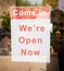 Come in we are open now Signage board in front of Businesses or Restaurant door after covid-19 or coronavirus outbreak - Concept