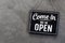 Come in we\\\'re open, vintage black retro sign in back wall