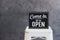 Come in we\\\'re open, vintage black retro sign in cafe