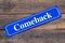 Comeback street sign on wooden background