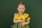 Comely girl in green dress is hugging bouquet of tulips as gift to mother