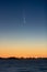 Comet Neowise, rising over the coast in the early morning twilight hours.