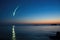 comet tail visible over serene ocean waters