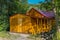 A comfortable beautiful sauna with a red roof made of wooden log cabin