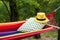 Comfortable bright hammock with soft pillow and hat at green garden, closeup