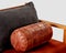 Comfortable copper-colored leather bolster cushion on soft sofa