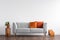 Comfortable couch with orange and red pillow in spacious living room interior,