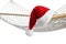 Comfortable hammock and Santa Claus hat on background, closeup. Christmas vacation