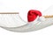 Comfortable hammock and Santa Claus hat on white background, closeup. Christmas vacation