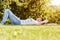 Comfortable happy woman lying in grass in autumn