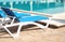 Comfortable loungers at clean swimming pool