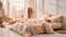 A comfy bedroom interior with a bed dressed in soft peach fuzz color bedding. Modern trendy tone hue shade