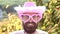 Comic man with funny hipster pink sunglasses and comic pink hat. Bearded crazy man looking at the camera. Make funny