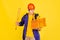 Comic portrait of young man, delivery guy in uniform isolated on yellow studio background. Concept of humor, safety