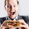Comical man eating sandwich with funny expression