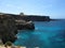 COMINO, MALTA - Apr 27, 2014: View of Santa Marija Tower, standing guard over the cliffs and blue sea of the island of Comino