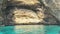 Comino, Malta, October 2023 - Popeye\'s Cave on a sunny day in October. Crystal clear emerald water surrounding