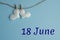 Commemorative date June 18 on a blue background with white hearts with clothespins, flat lay. Holiday calendar concept