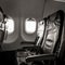 Commercial aircraft cabin with rows of seats down the aisle. Retro Black and white filter