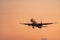 Commercial airline. Passenger plane landing at airport with beautiful sunset sky and clouds. Arrival flight. Airplane flying