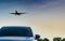 Commercial airline. Passenger plane landing approach blue SUV car at airport with blue sky and clouds at sunset. Arrival flight.