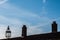 Commercial airplane flying over Tudor period rooftop with chimneys