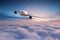 Commercial airplane jetliner flying above dramatic clouds.