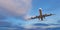 Commercial airplane jetliner flying above dramatic clouds.