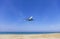 Commercial airplane landing above sea and clear blue sky over beautiful scenery nature background location at mai khao beach