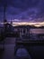 Commercial boat dock silhouette and dramatic cloudscape at twilight blue hours over the empty marina on Cape Cod Island.