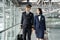 Commercial cabin crew or hostress and pilot occupation concepts. Asian airliner pilot and air hostess walking and talking together