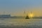 Commercial ship sailing on the river near a bridge during sunset