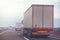 Commercial trailer truck in motion on freeway on cloudy afternoon