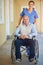 Committed to his comfort and care. a doctor pushing her senior patient in a wheelchair.