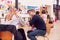 Communal Area Of Busy College Campus With Students Working At Tables