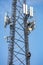 Communication maintenance. Technician climbing on telecom tower against blue sky background