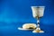Communion still life. Unleavened bread, chalice of wine, silver kiddush wine cup on blue background. Christian communion concept