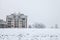 Communist housing buildings in front of a frozen hill in Pancevo, Serbia, during a afternoon with snow.