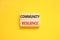 Community resilience symbol. Concept word Community resilience typed on wooden blocks. Beautiful yellow table yellow background.