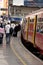 A commuter train at London Waterloo station with passengers walking along the platform