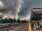 Commuters wait for the train while standing on a Chicago suburbs station platform during a stormy summer morning