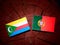 Comoros flag with Portuguese flag on a tree stump isolated