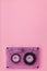 Compact audio tape cassette on pink background