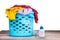 Compact concentrated laundry liquid detergent next to basket full of apparels