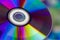 Compact Disc. Holding a CD in hands. The back side of the CD reflects colorful lights. Rainbow colors