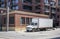 Compact small rid semi truck with box trailer standing in down town for loading moving goods