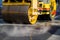 The compact steamroller will flatten the asphalt during repairs.