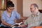 Companion or granchild reading to senior or grandfather