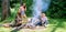 Company adult friends relaxing near campfire. Summer vacation. Friends spend leisure weekend forest nature background